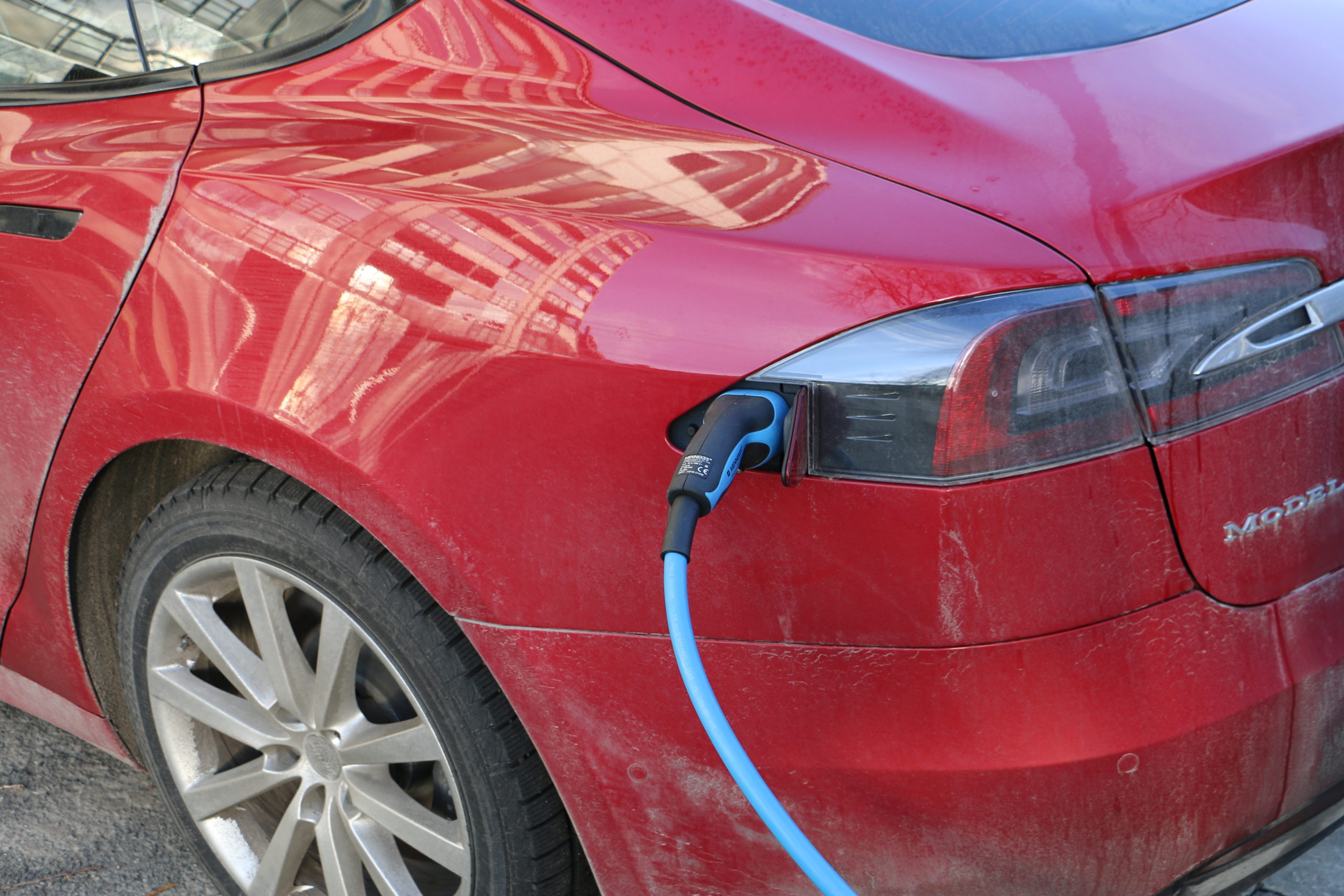 Rød tesla koblet i lader